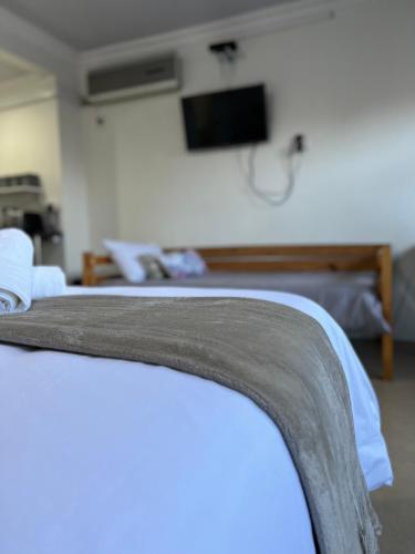 Bella Lux Holiday Condos في ديربان: غرفة بها سريرين وتلفاز على الحائط