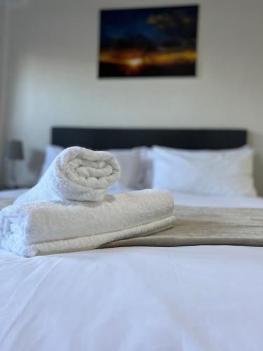 a stack of towels sitting on top of a bed at Bella Lux Holiday Condos in Durban