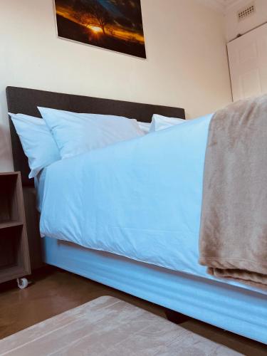 a bed with blue sheets and pillows in a room at Bella Lux Holiday Condos in Durban