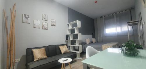 a living room with a couch and a bed at Apartamentos Las trece llaves Jacuzzi bajo reserva in Merida