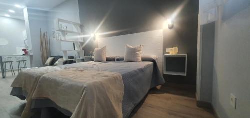 a bedroom with a bed with white sheets and pillows at Apartamentos Las trece llaves Jacuzzi bajo reserva in Merida