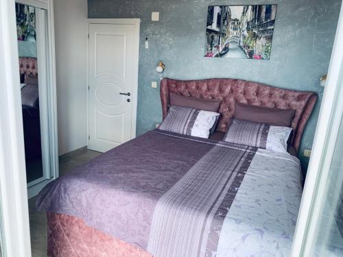 ein Schlafzimmer mit einem großen Bett mit einer lila Bettdecke in der Unterkunft Vila Wolf Montenegro in Budva