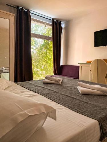 a hotel room with a bed with two towels on it at Oneiro Resort in Mamaia Sat/Năvodari