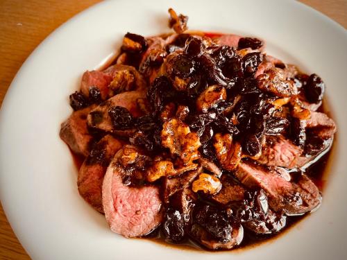 a plate of food with meat and raisins at Okushiga Lodge Yama no Manimani in Yamanouchi