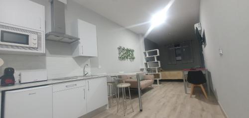 a kitchen with white cabinets and a table and chairs at Apartamentos Las trece llaves Jacuzzi bajo reserva in Merida