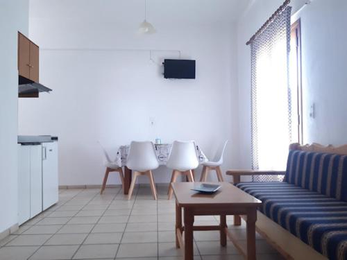 a living room with a couch and a table and chairs at Skiathos Maria Apartments in Skiathos Town