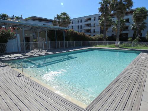 une grande piscine avec une terrasse en bois dans l'établissement Sète: Superbe T2 52m² avec Parking, Clim, Wifi - FR-1-472-169, à Sète
