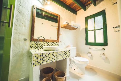 a bathroom with a sink and a toilet and a mirror at Estancia San Antonio in Guasca
