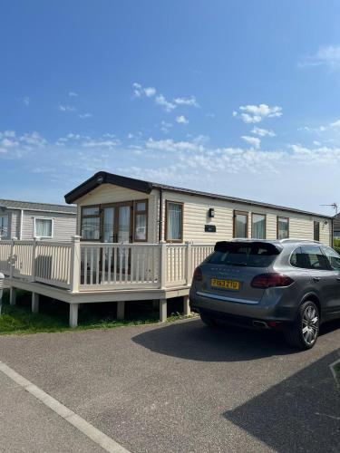 a house with a car parked in front of it at Seascape Horizon at Camber Sands in Camber