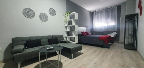 sala de estar con sofá y cama en Apartamentos Las trece llaves Jacuzzi bajo reserva, en Mérida