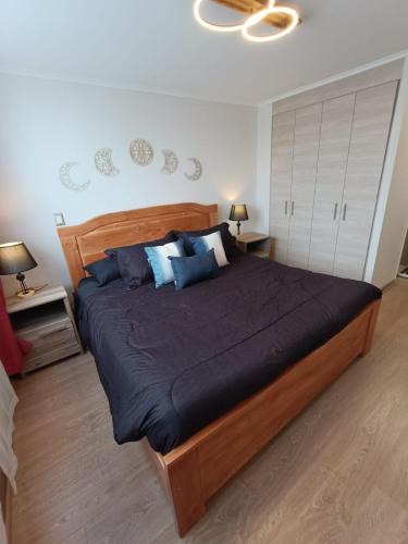 a bedroom with a large bed with blue pillows at Departamento, Condominio Nueva Villarrica in Villarrica