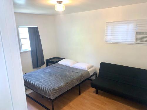 een kleine kamer met een bed en een bank bij Charm West Valley Perfect Location by Westfield Topanga in Los Angeles