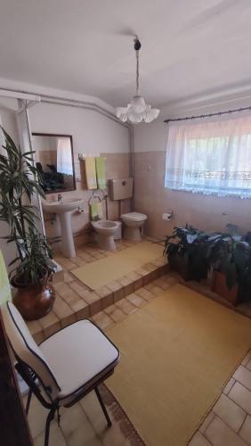 a bathroom with two toilets and a sink and a chair at Casa do Artesanato in Vila Nova de Cerveira