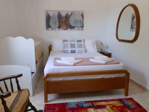 a bedroom with a bed with a mirror on the wall at Kedrodasos House in Elafonisi