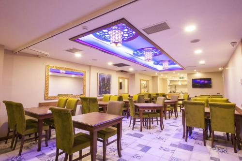 una sala da pranzo con tavoli, sedie e tavola di Hotel Ney a Konya