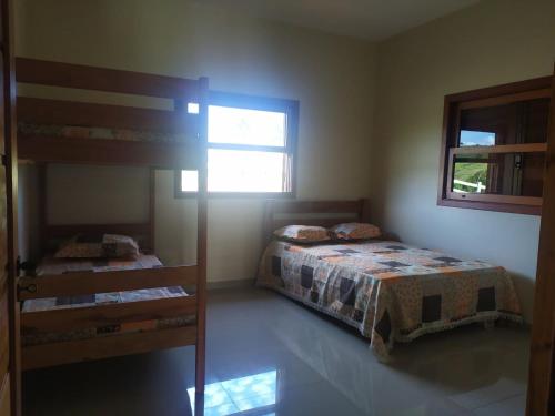 a bedroom with two bunk beds and a window at Sítio da Pedra in Cunha