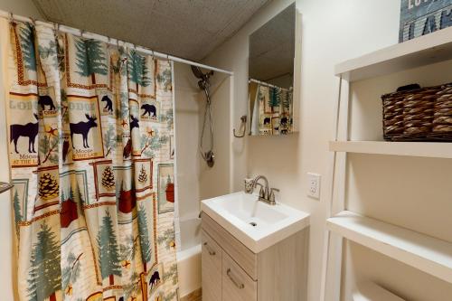 a bathroom with a shower curtain and a sink at Lake Den in Vassalboro