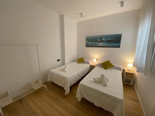 a white room with two beds and a window at Lovely Capuchinos in Málaga