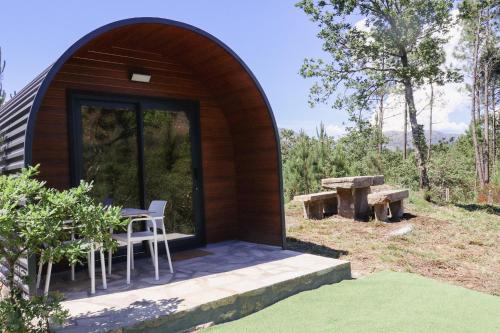 a small wooden cabin with a table and a bench at Outeiro do Moinho in Campo do Gerês