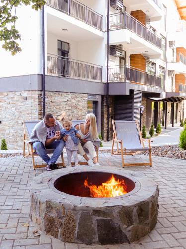 a family sitting around a fire pit in a courtyard at Apartel Shayan in Shaian