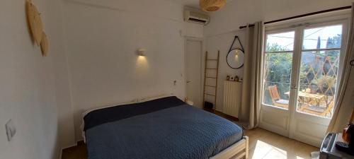 Un dormitorio con una cama azul y una ventana. en La Mandynia Studio, en Kato Korakiana