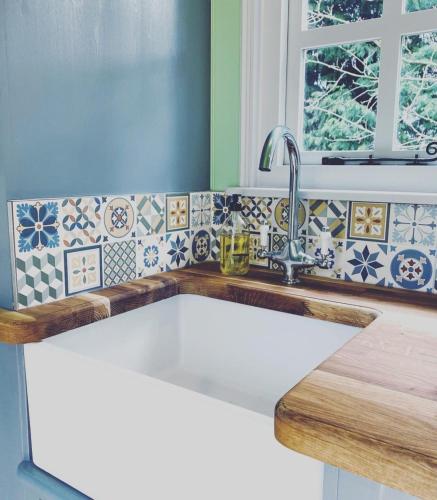 a kitchen counter with a sink in a kitchen at Jasmine The Shepherd Hut in Woodhall Spa