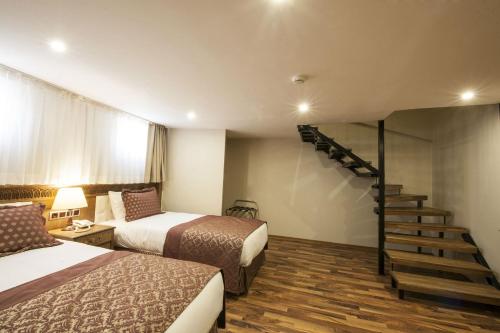 a hotel room with two beds and a staircase at Hotel Ney in Konya