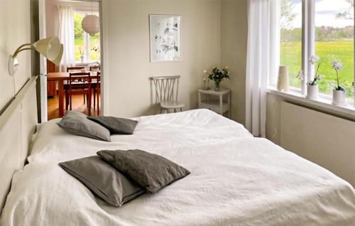 a bedroom with a white bed with two pillows on it at Gorgeous Home In Lyrestad With Wifi in Lyrestad
