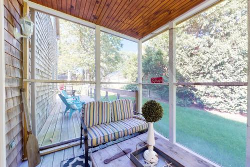 a screened in porch with a chair and a table at Sunny Side Up in Oak Bluffs