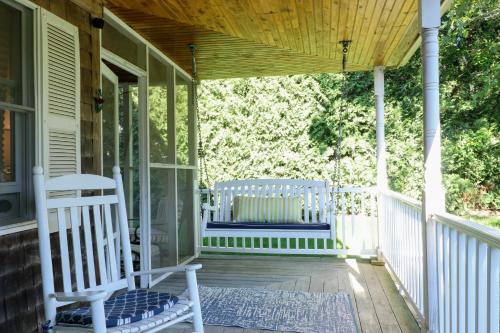 a porch with two white rocking chairs on it at Sunny Side Up in Oak Bluffs