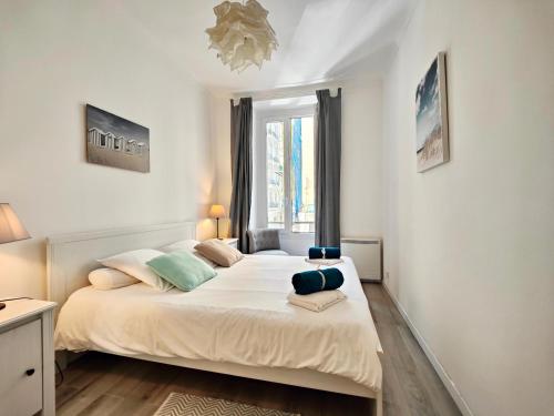 une chambre avec un grand lit blanc avec une fenêtre dans l'établissement Le Cosy Meyerbeer by Booking Guys, à Nice