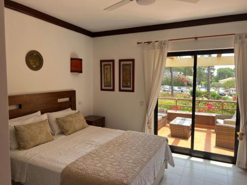 una camera da letto con un letto e un balcone di Falesia Beach Town house 2 bedroom a Olhos de Água
