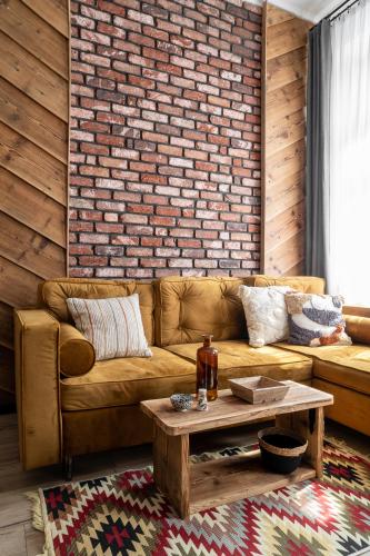 a living room with a couch and a brick wall at Apartament Czarna Perła in Czarny Dunajec