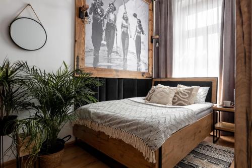 a bedroom with a bed with a picture on the wall at Apartament Czarna Perła in Czarny Dunajec