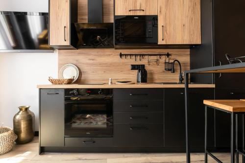 a kitchen with a stove and a microwave at Apartament Czarna Perła in Czarny Dunajec