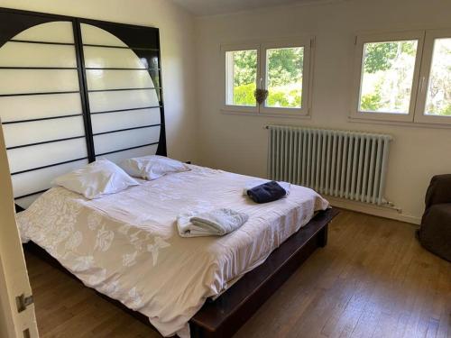 a bedroom with a bed with white sheets and pillows at Villa - Coulommiers - Parcs des félins - Provins in Saints