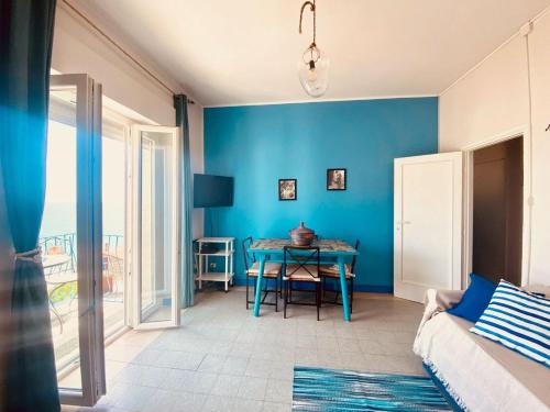 sala de estar con mesa y pared azul en CasaAzul, en Sperlonga