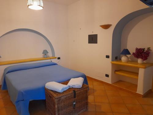 a bedroom with a bed with a basket and a table at Casa Mandarino Forio Ischia in Ischia