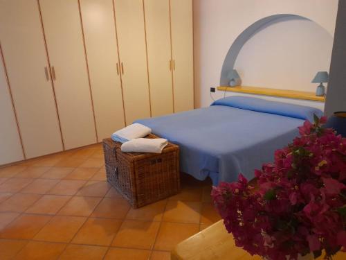 a bedroom with a bed and a basket and flowers at Casa Mandarino Forio Ischia in Ischia