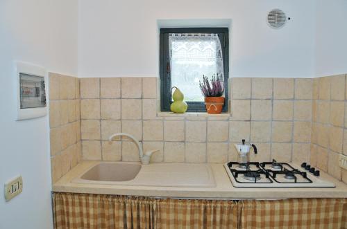 a kitchen counter with a sink and a window at Trulli Vulés in Ostuni