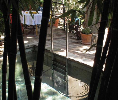 a view of a swimming pool with a table and a table at La Maison Sur La Sorgue - Esprit de France in LʼIsle-sur-la-Sorgue