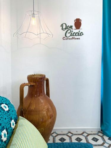 a brown vase sitting next to a sign on a wall at Don Ciccio Capashome in Ceglie Messapica