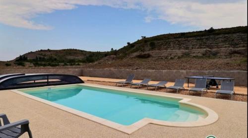 - une piscine avec des chaises et une table dans l'établissement Mas de charme avec piscine chauffée, à Rosières