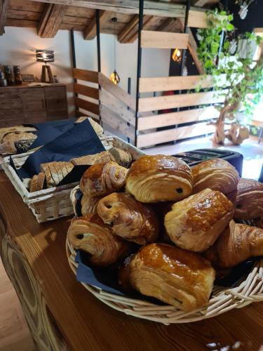 a basket filled with different types of pastries on a table at CHALET 1703 - Refuge Alpin avec Spa & Sauna - l'esprit maison au Coeur des Alpes - Adults Only in Le Petit-Bornand-lès-Glières