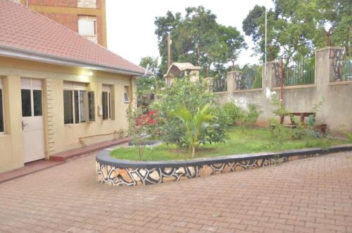 a courtyard with a bench in front of a building at Jusvero Motel in Jinja