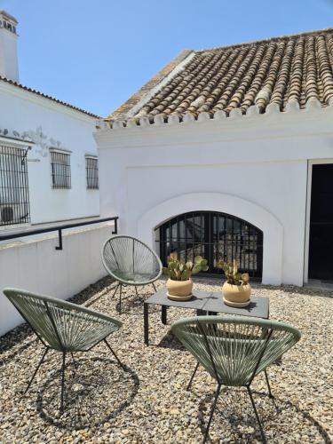 patio z dwoma krzesłami i stołem przed domem w obiekcie Bodega Mar - Velo de Flor w mieście Sanlúcar de Barrameda