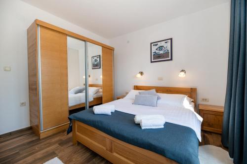 a bedroom with a large bed and a mirror at Lucija in Starigrad-Paklenica