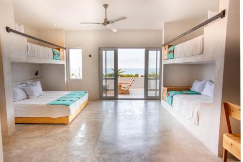 Topia Retreat- Surf Suite Norte في El Pescadero: سريرين في غرفة مطلة على المحيط