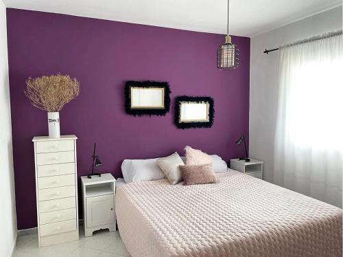 a purple bedroom with a bed and a purple wall at Ocean Kiss Apartment in Puerto del Carmen