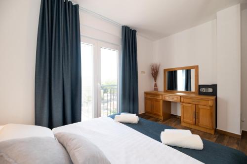 a hotel room with two beds and a television at Lucija in Starigrad-Paklenica